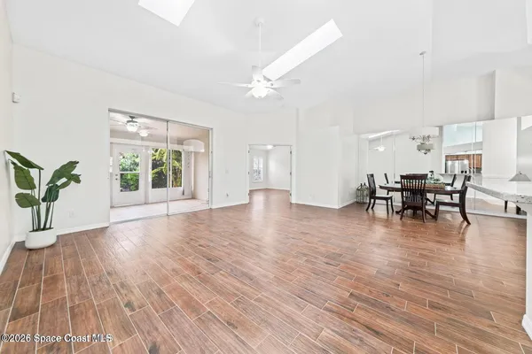 a view of empty room with wooden floor and floor to ceiling window
