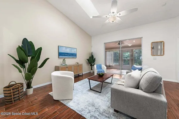 a living room with furniture a potted plant and a rug
