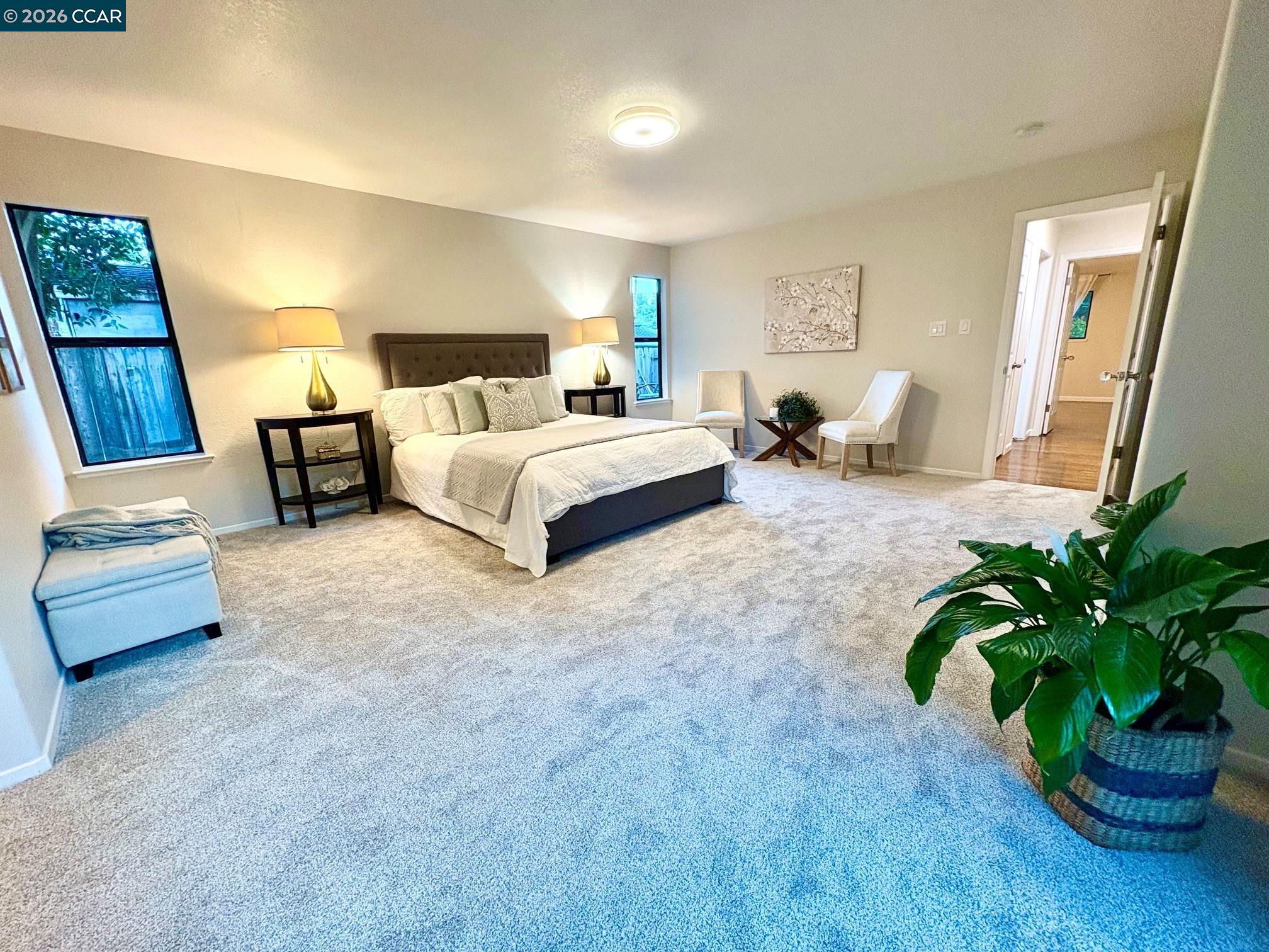 2589 Pebble Beach Loop Lafayette, CA 94549 - Photo 17 of 32 a spacious bedroom with a bed table flowerpot and window