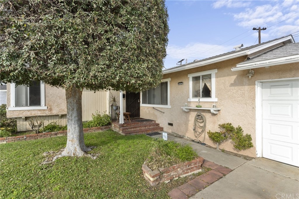 12042 Hackamore Road Garden Grove, CA 92840 - Photo 1 of 20 a front view of a house with a yard and garage