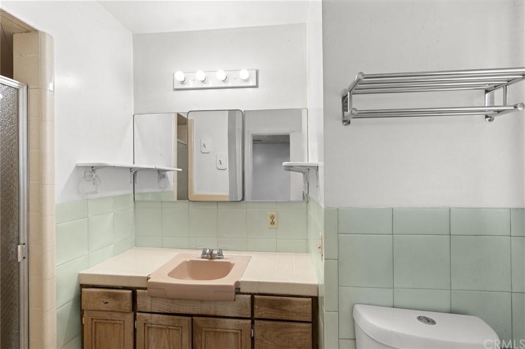 12042 Hackamore Road Garden Grove, CA 92840 - Photo 11 of 20 a bathroom with a sink a toilet and mirror