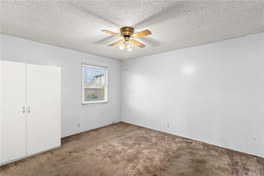 12042 Hackamore Road Garden Grove, CA 92840 - Photo 14 of 20 an empty room with windows and chandelier fan