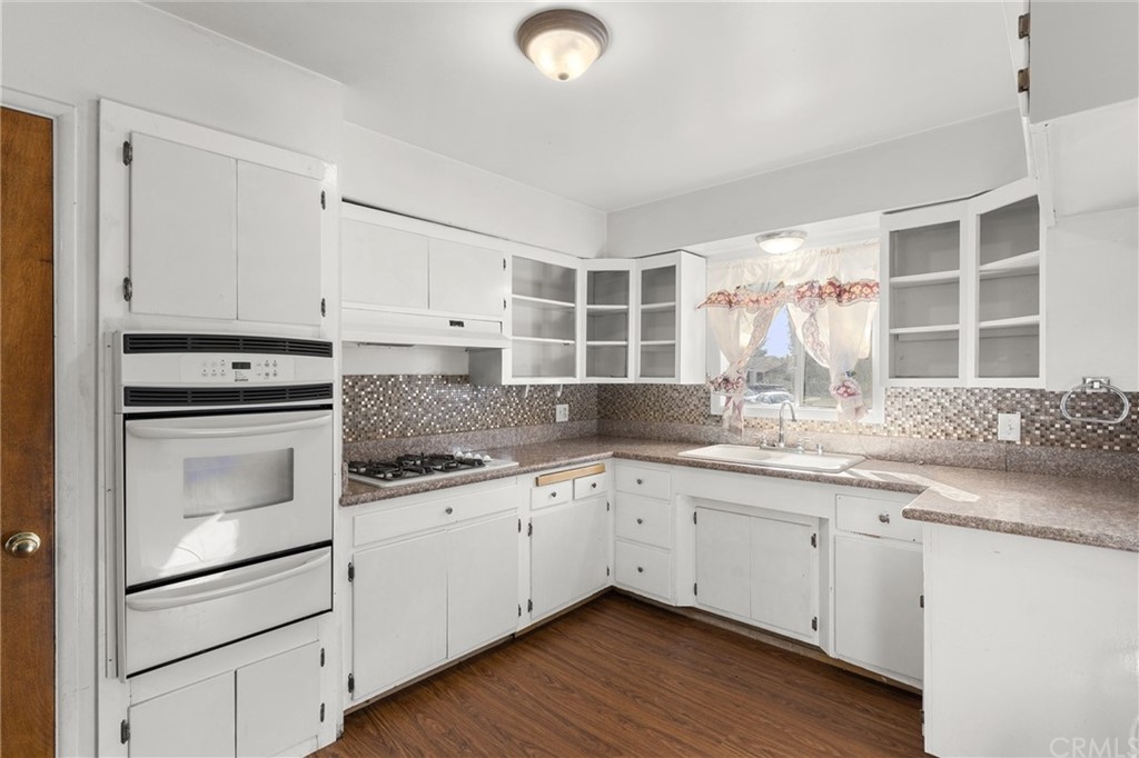12042 Hackamore Road Garden Grove, CA 92840 - Photo 7 of 20 a kitchen with granite countertop white cabinets and white appliances
