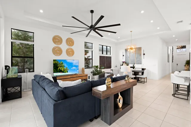 a living room with furniture a chandelier and a flat screen tv