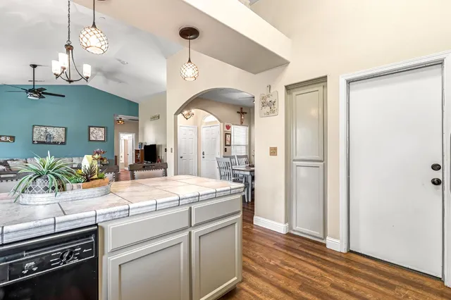 a kitchen with a sink a counter space appliances and cabinets