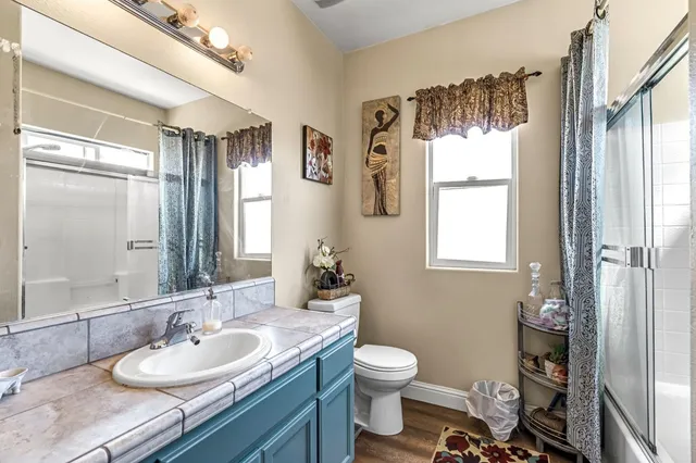 a bathroom with a granite countertop sink toilet and shower