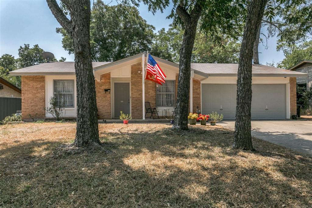 a view of a house with backyard and trees