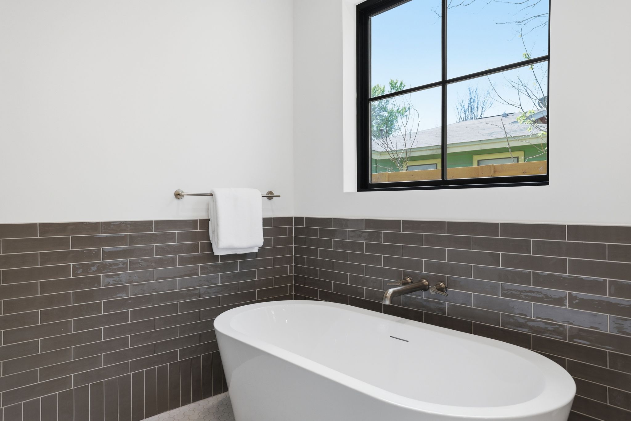 4500 Jinx Avenue Austin, TX 78745 - Photo 24 of 40 Bathroom featuring a soaking tub, tile walls, and wainscoting