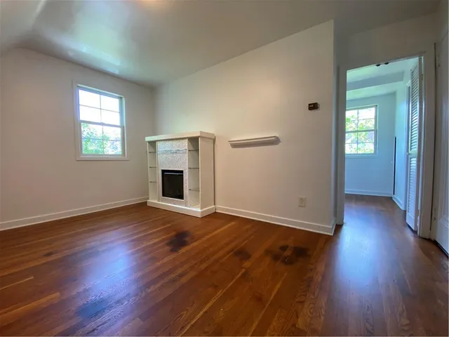 an empty room with wooden floor and fireplace