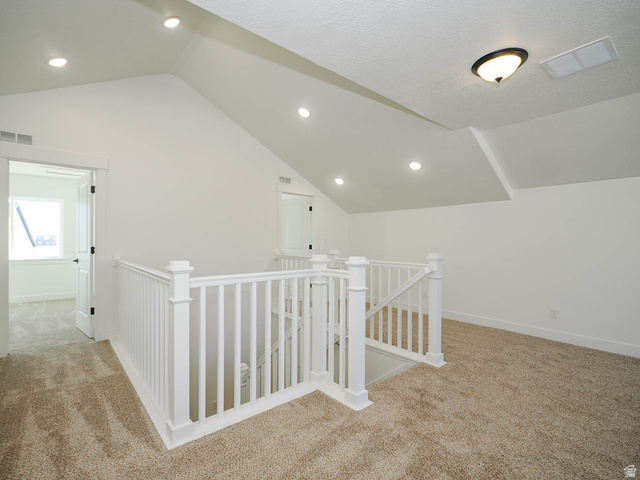 3938 North Wood Road Eagle Mountain, UT 84005 - Photo 32 of 55 Hall featuring an upstairs landing, light colored carpet, vaulted ceiling, and recessed lighting