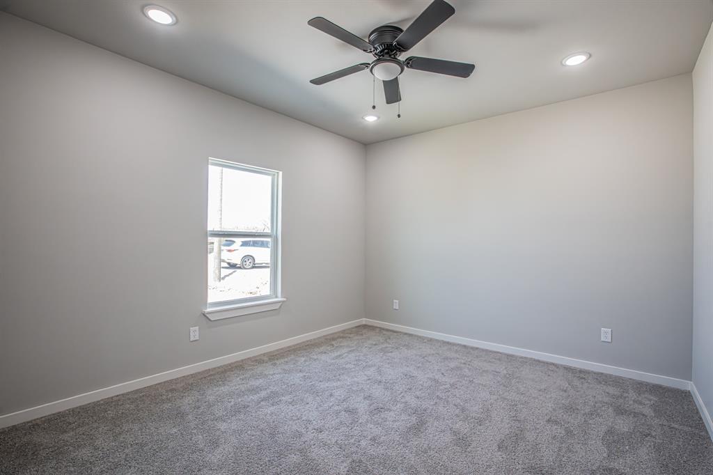 124 Brookview Drive Jacksboro, TX 76458 - Photo 12 of 34 en empty room with windows and ceiling fan