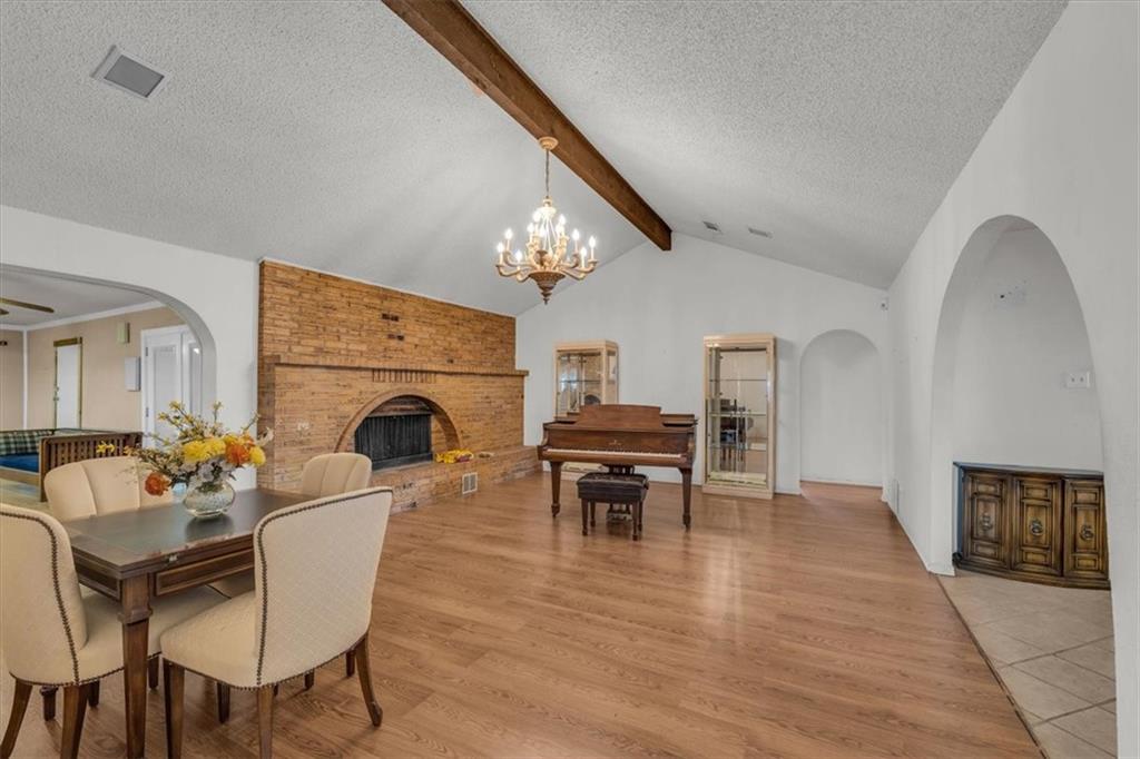 1064 Warren Road Lorena, TX 76655 - Photo 17 of 34 a living room with furniture a fireplace and a dining table with wooden floor