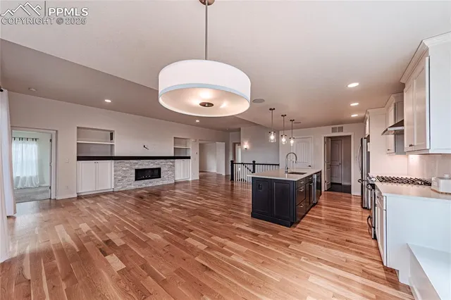 a kitchen with stainless steel appliances granite countertop a sink a stove a refrigerator and island