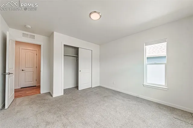 an empty room with windows and closet