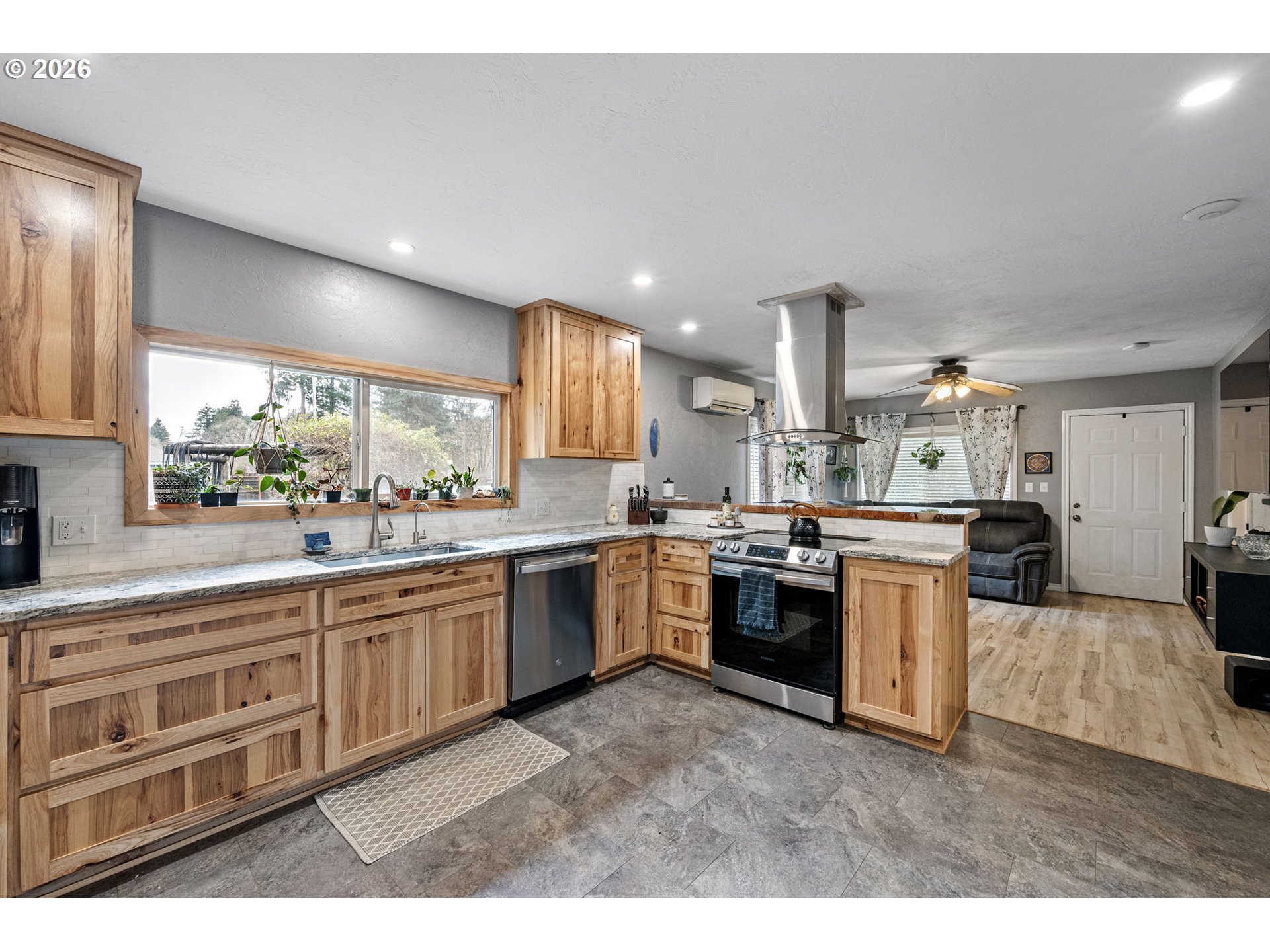 74129 London Road Cottage Grove, OR 97424 - Photo 11 of 44 a large kitchen with kitchen island granite countertop a large counter top space a sink stainless steel appliances and cabinets
