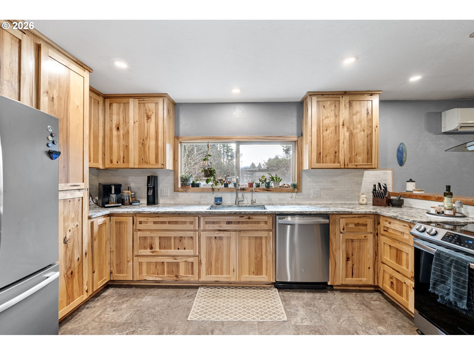 74129 London Road Cottage Grove, OR 97424 - Photo 10 of 44 a kitchen with stainless steel appliances granite countertop a stove a sink dishwasher a refrigerator and white cabinets with wooden floor