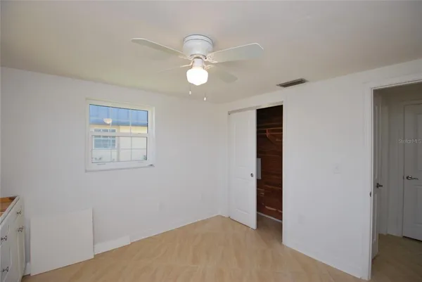 a view of an empty room with closet and wooden floor