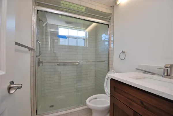 a bathroom with a sink a toilet and shower