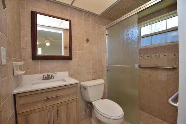a bathroom with a toilet a sink a mirror and a shower