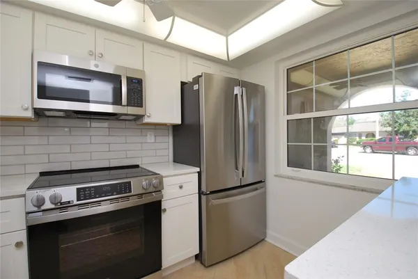 a kitchen with stainless steel appliances a stove microwave and refrigerator