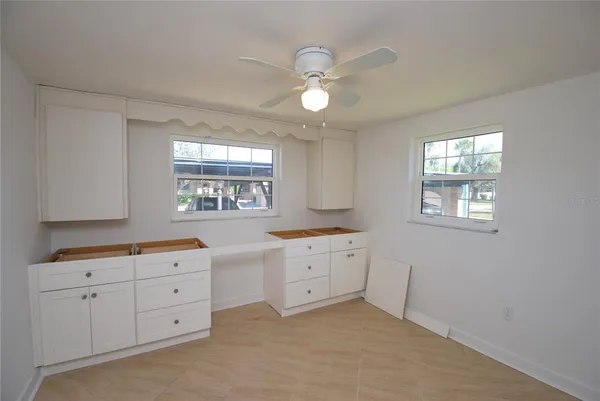 a kitchen with white cabinets and window