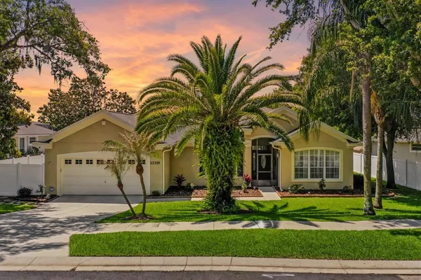 a front view of a house with a garden and trees
