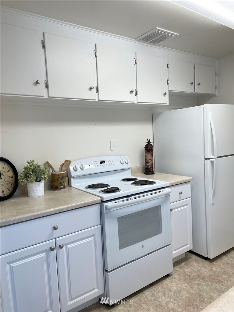 381 Patrick Road Ephrata, WA 98823 - Photo 11 of 32 a kitchen with white cabinets and white appliances