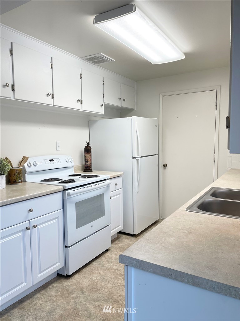 381 Patrick Road Ephrata, WA 98823 - Photo 12 of 32 a kitchen with white cabinets and white appliances