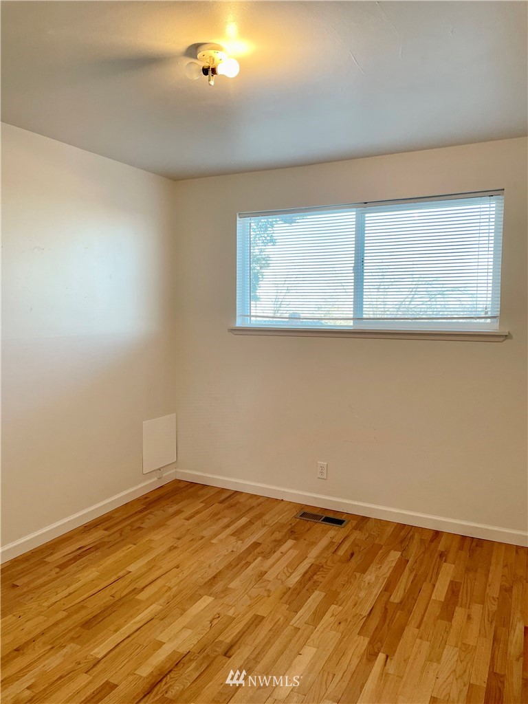 381 Patrick Road Ephrata, WA 98823 - Photo 23 of 32 a view of an empty room with wooden floor and a window