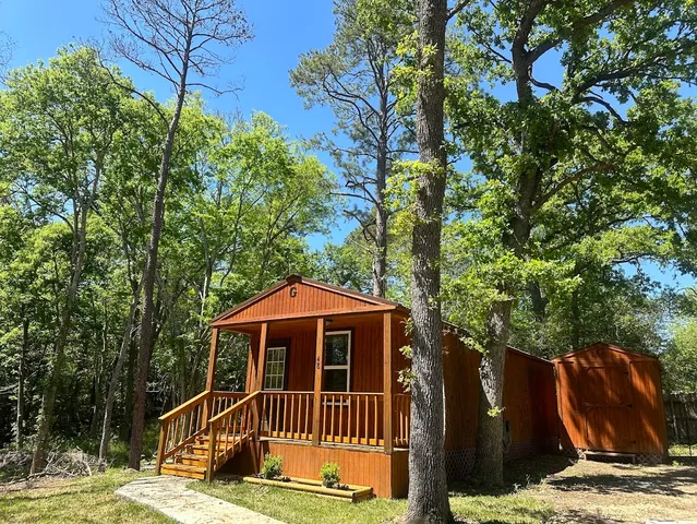 a view of a wooden house with a small yard