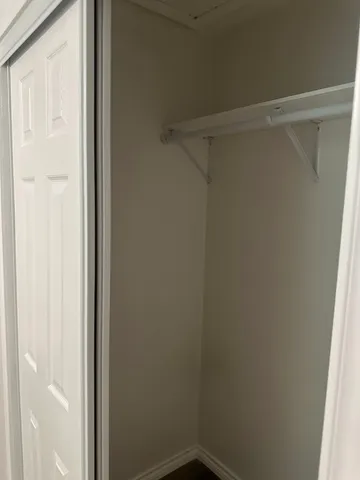 an empty room with wooden floor cabinet and windows