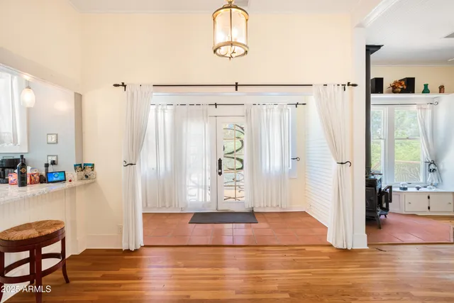 a room with stainless steel appliances a kitchen island hardwood floor and a sink