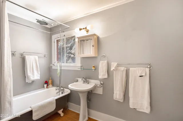 a view of a bedroom with wooden floor and window