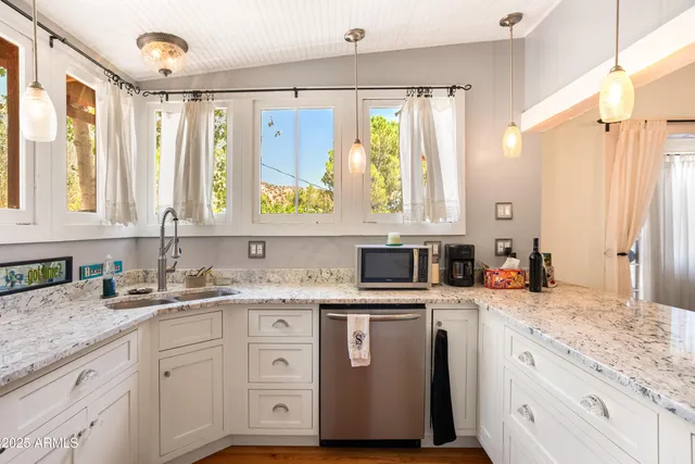 a large kitchen with kitchen island a large counter top space a sink stainless steel appliances and cabinets