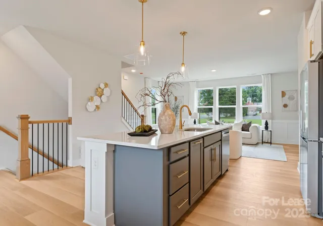 a kitchen with stainless steel appliances granite countertop a sink and a wooden floor
