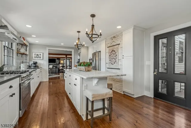 a large kitchen with stainless steel appliances granite countertop a sink stove and refrigerator