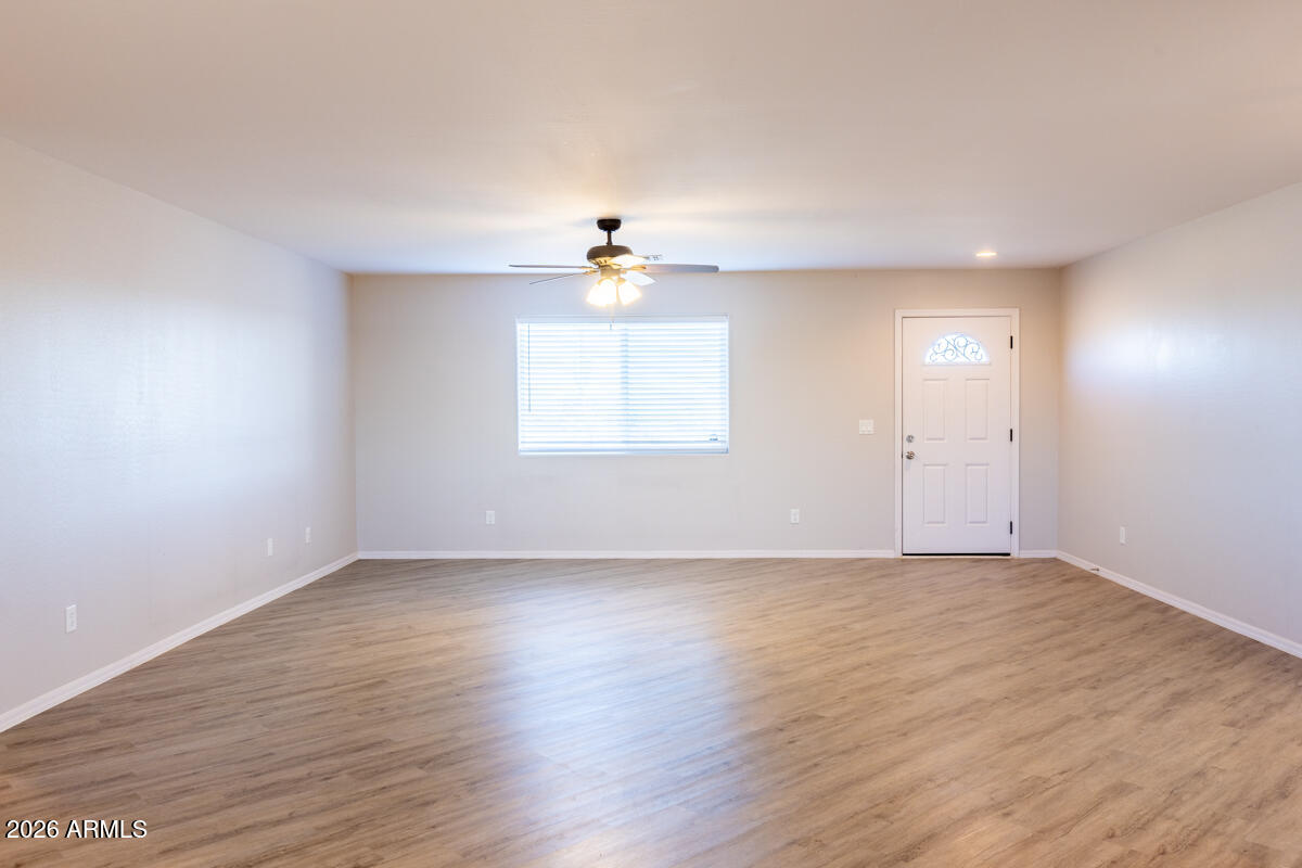 24638 East Bartlett Road Florence, AZ 85132 - Photo 11 of 21 an empty room with wooden floor and windows