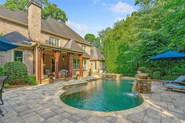 a view of a house with backyard patio and swimming pool
