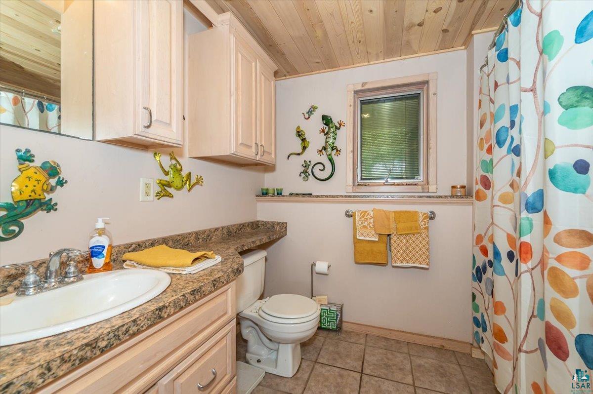 11758 South Long Lake Road Solon Springs, WI 54873 - Photo 17 of 38 Bathroom featuring wood ceiling, toilet, vanity, and tile patterned floors