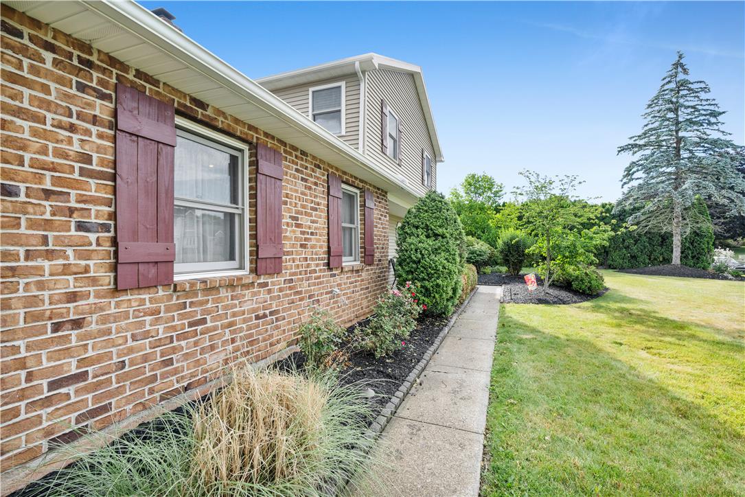 3396 Darien Road Bethlehem, PA 18020 - Photo 4 of 44 Mature trees and landscaping frame this charming brick home with red-toned window shutters.