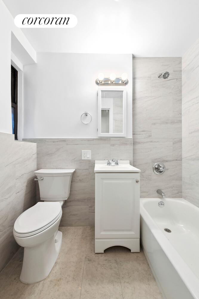 44-14 Newtown Road, Unit 1O Queens, NY 11103 - Photo 6 of 7 a bathroom with a toilet sink and mirror