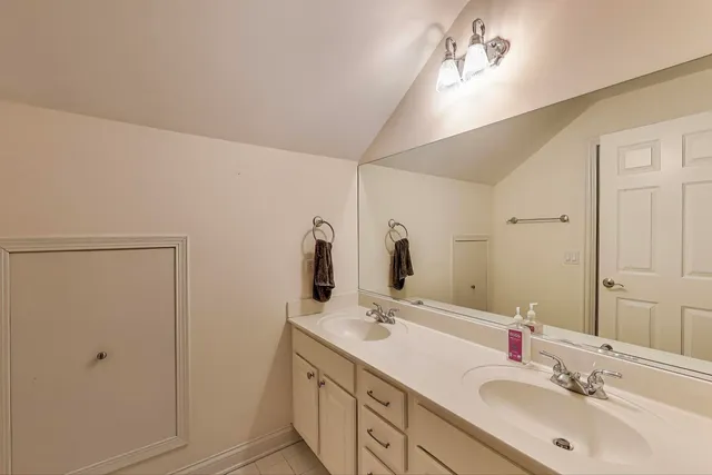 a bathroom with double vanity sink and a mirror