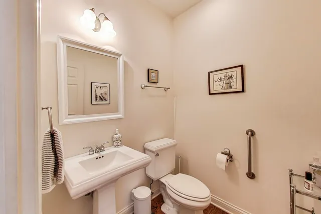 a bathroom with a toilet a sink and mirror