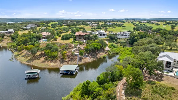 an aerial view of a house with a yard and lake view