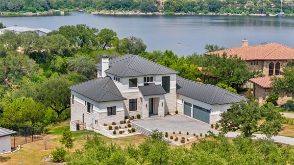 an aerial view of a house with outdoor space and a lake view