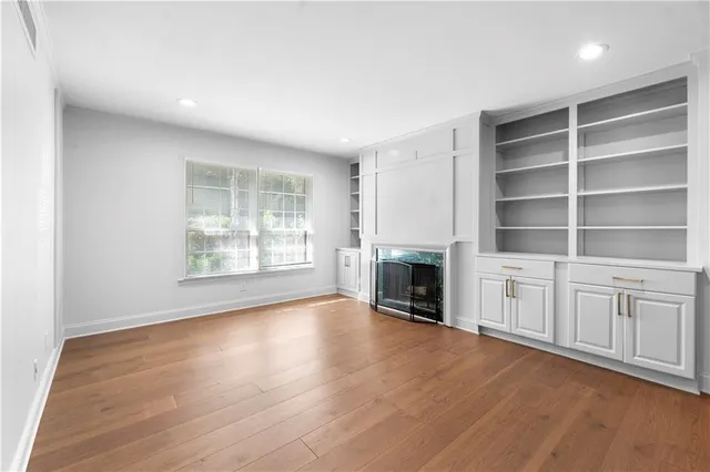 a view of a livingroom with wooden floor and a fireplace