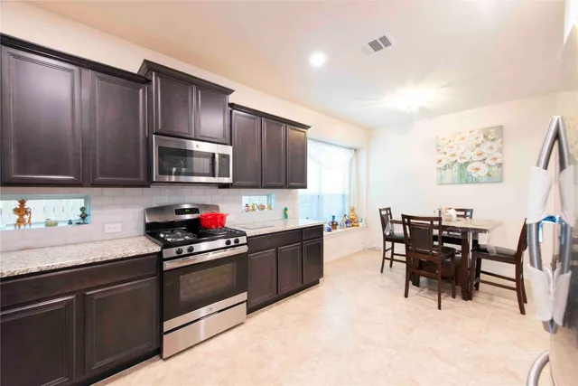 a kitchen with granite countertop a sink cabinets and stainless steel appliances