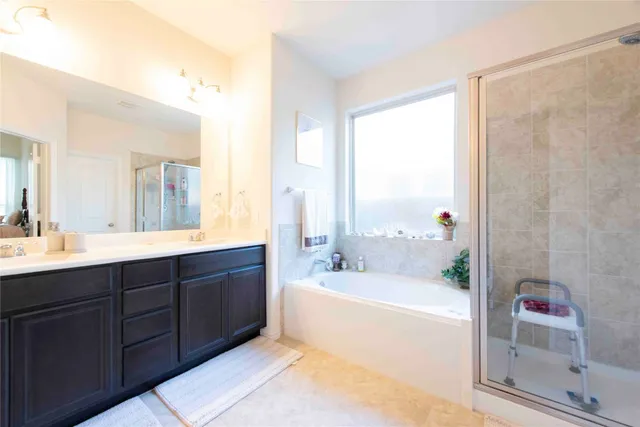 a spacious bathroom with a tub sink shower and mirror