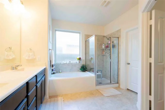 a spacious bathroom with a tub shower and sink