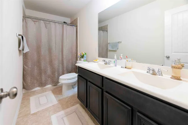 a bathroom with a double vanity sink toilet and shower
